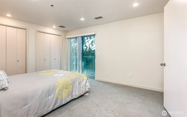 a bedroom with a bed and a large window