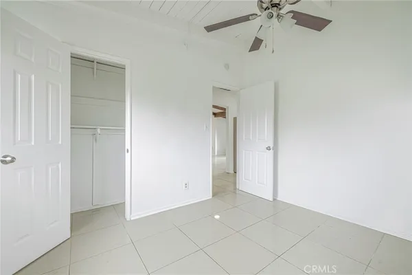 a view of an empty room with window and closet area