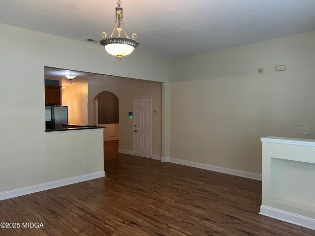 a view of a room with wooden floor and entryway