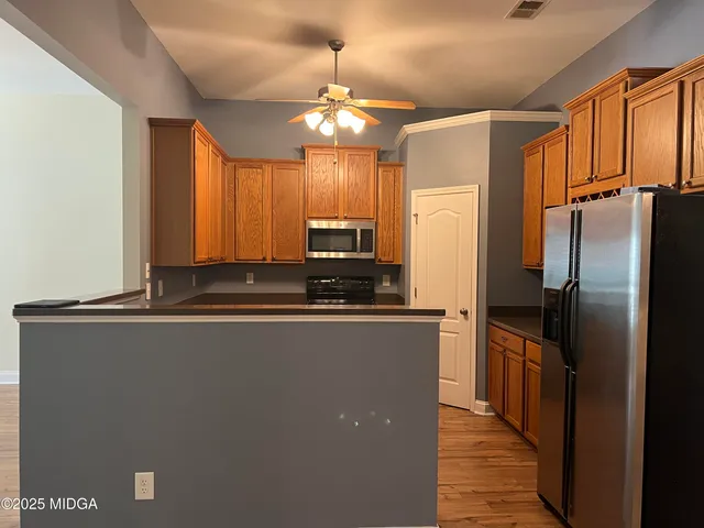 a kitchen with stainless steel appliances granite countertop a refrigerator a sink and a stove