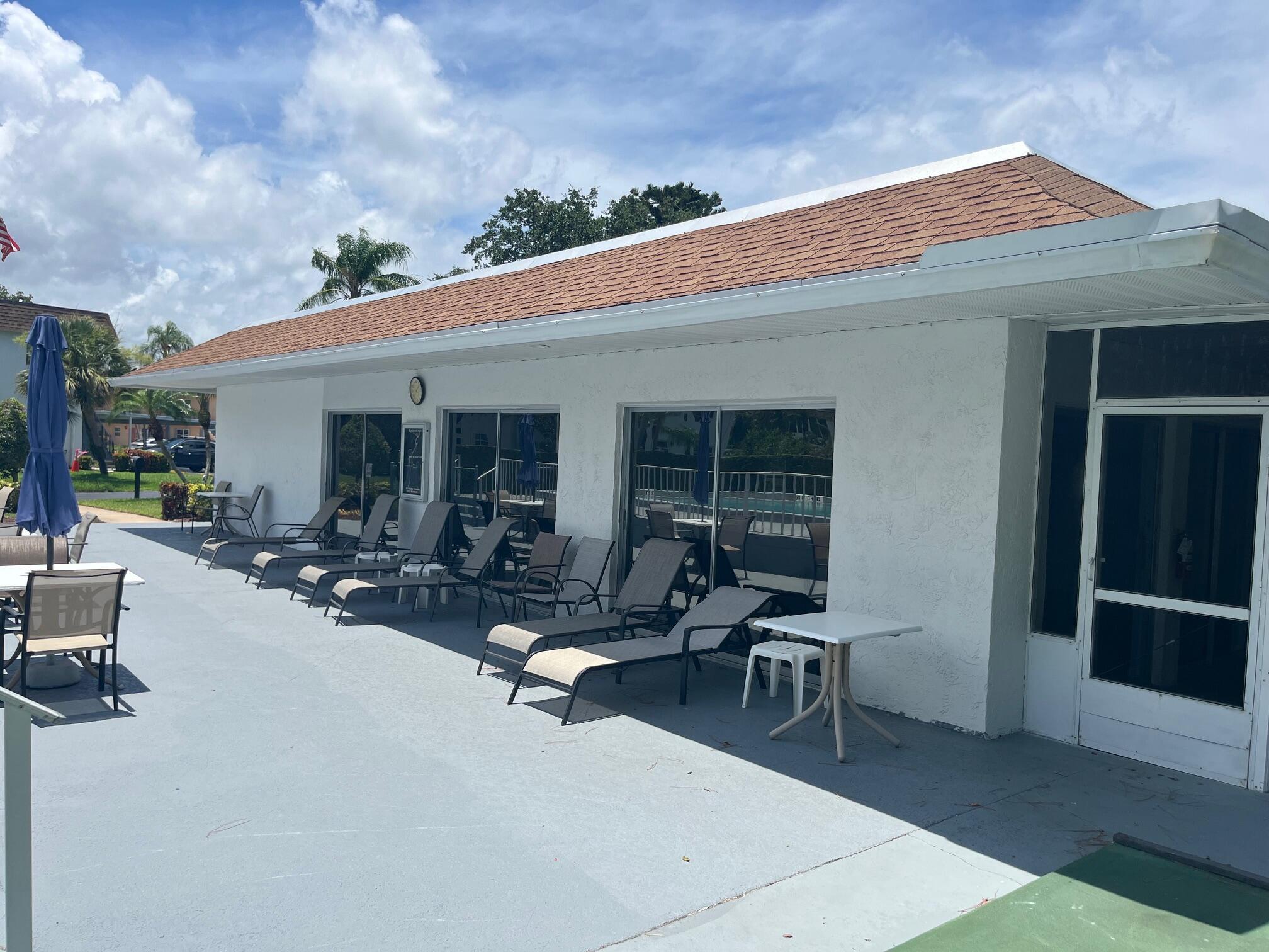 2950 Southeast Ocean Boulevard, Unit 75 Stuart, FL 34996 - Photo 19 of 19 a view of a patio with table and chairs and potted plants