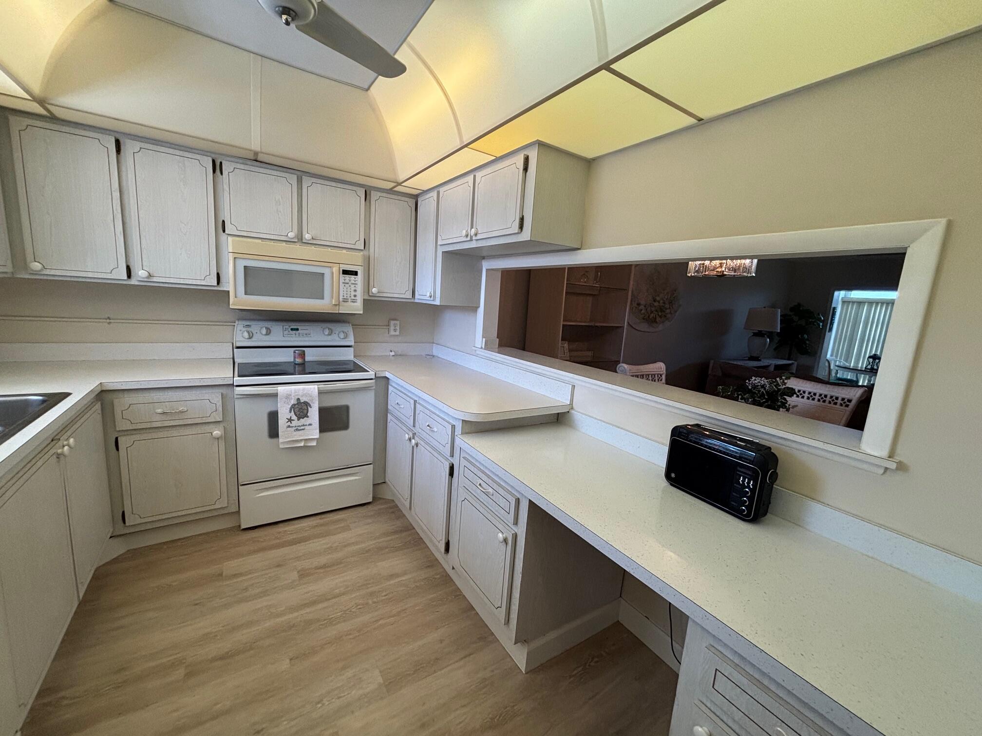 2950 Southeast Ocean Boulevard, Unit 75 Stuart, FL 34996 - Photo 3 of 19 a kitchen with stainless steel appliances a stove a microwave a sink and cabinets