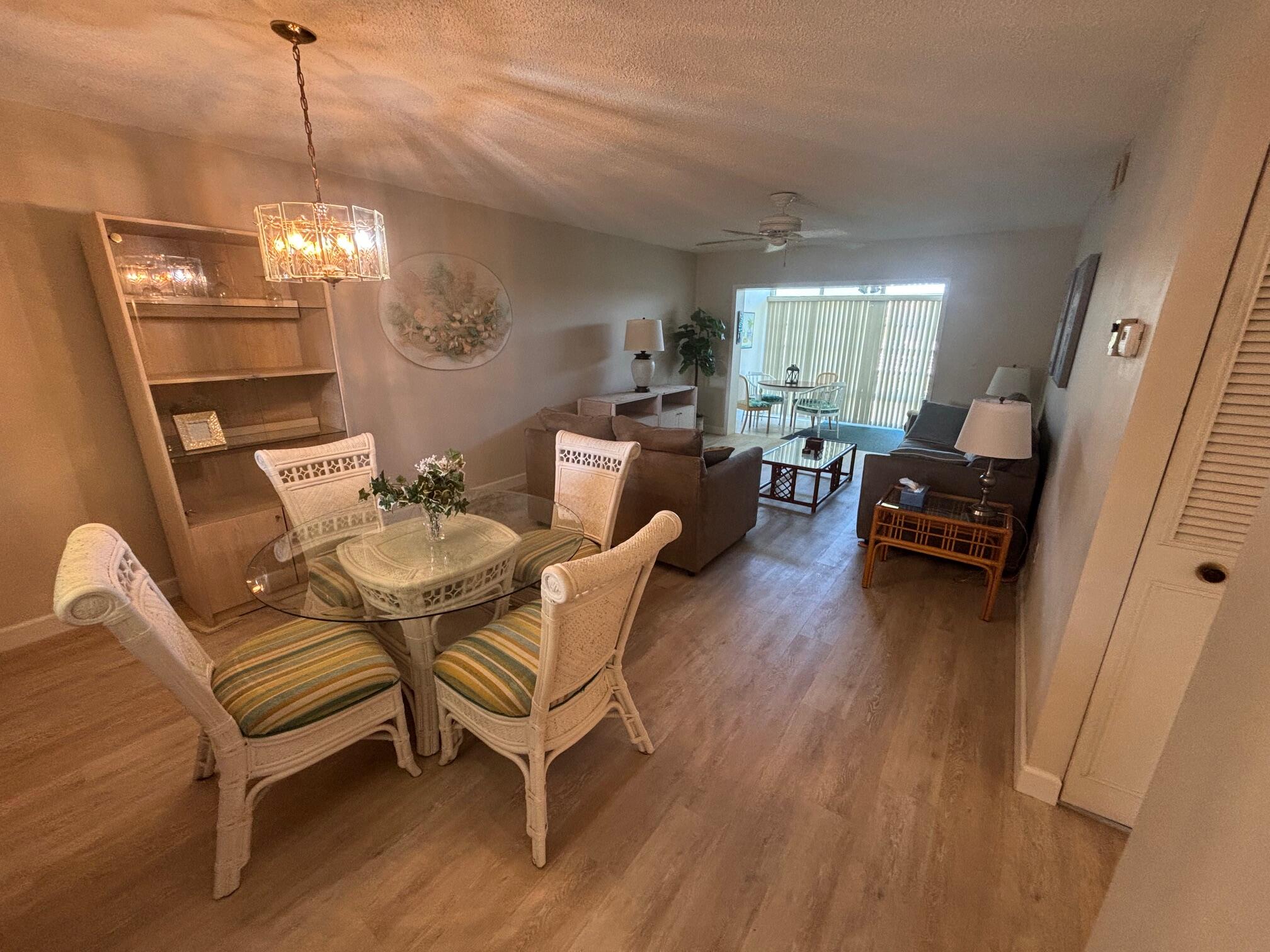 2950 Southeast Ocean Boulevard, Unit 75 Stuart, FL 34996 - Photo 6 of 19 a living room with furniture and a chandelier