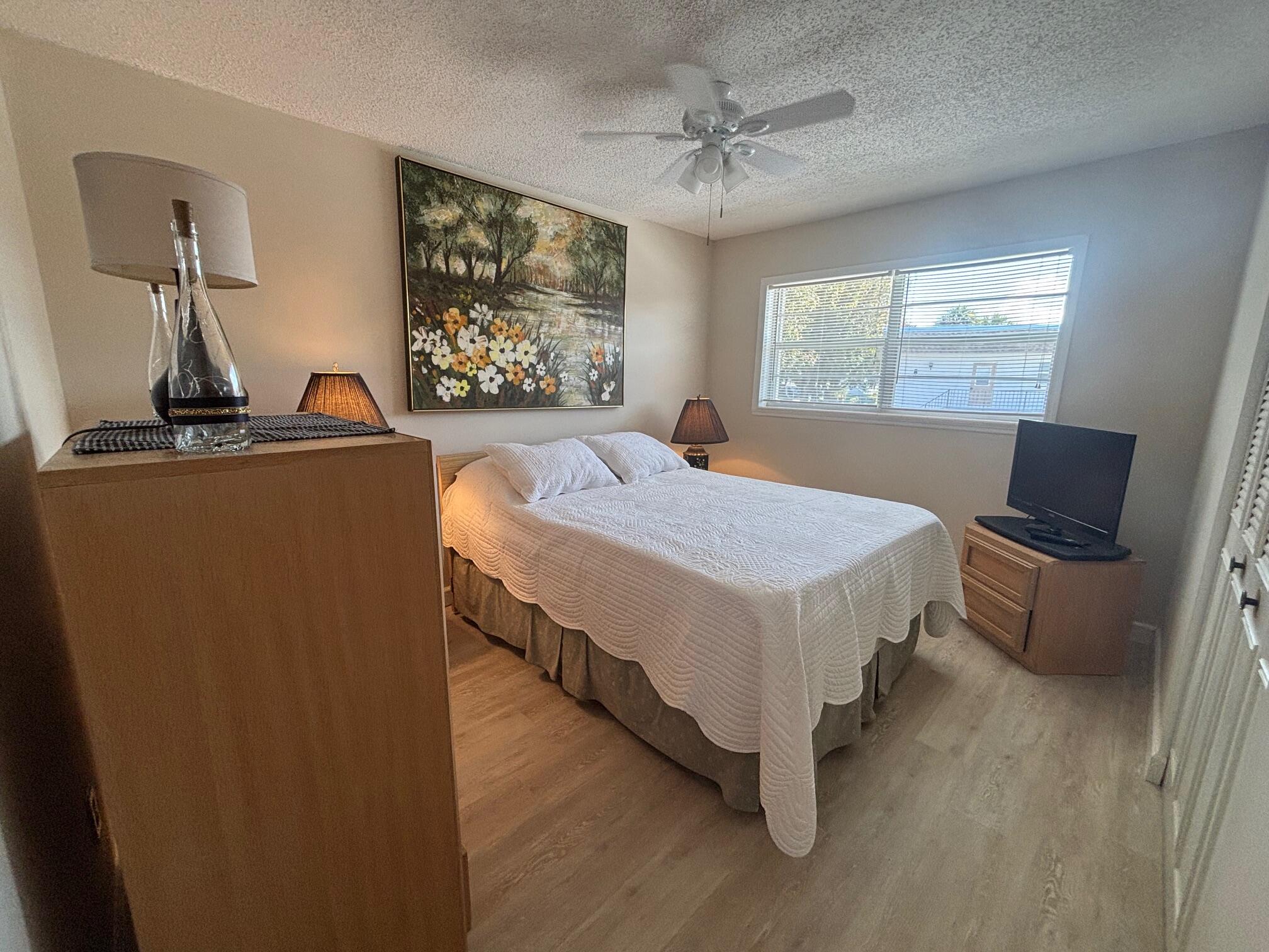 2950 Southeast Ocean Boulevard, Unit 75 Stuart, FL 34996 - Photo 9 of 19 a bedroom with a bed and a flat screen tv
