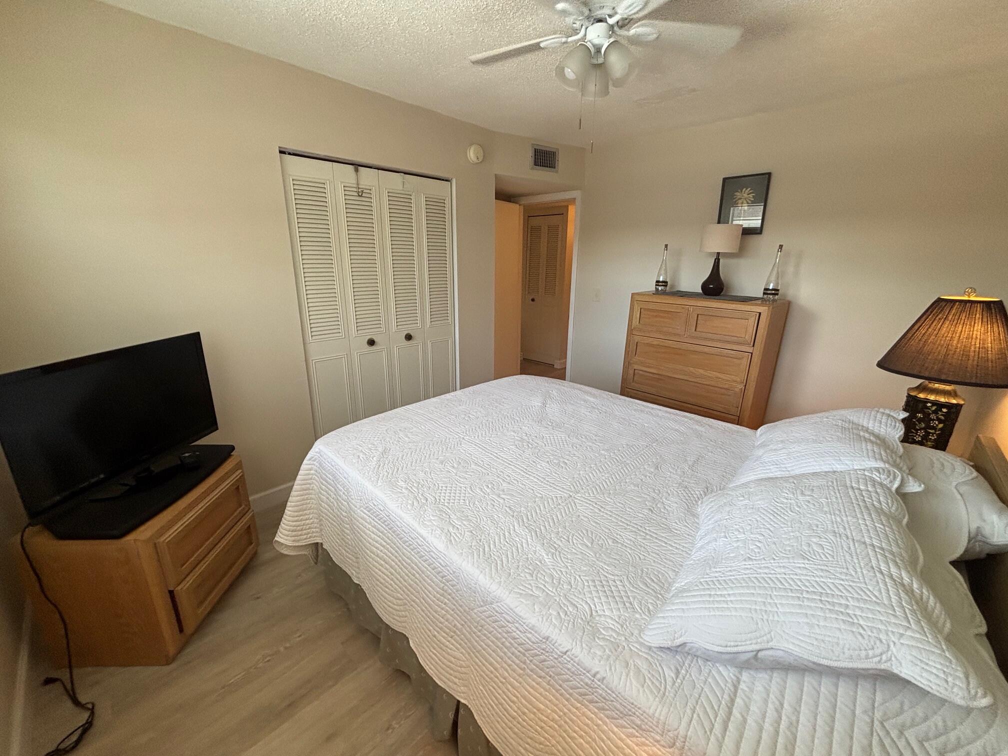 2950 Southeast Ocean Boulevard, Unit 75 Stuart, FL 34996 - Photo 10 of 19 a bedroom with a bed and a flat screen tv