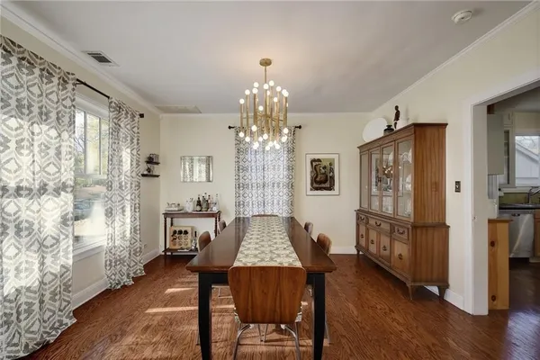 a kitchen with stainless steel appliances granite countertop a refrigerator a sink dishwasher a stove and white countertops with wooden floor