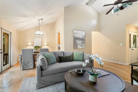 a view of a dining room with furniture a chandelier and a large window