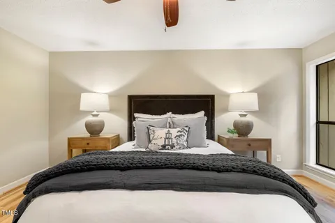 a bedroom with a large bed and a chandelier fan