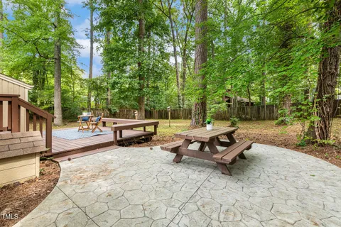 a backyard of a house with barbeque oven table and chairs