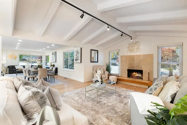 a living room with furniture large window and a fireplace