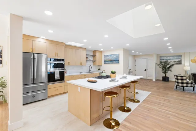 a kitchen with stainless steel appliances a stove a sink a refrigerator and cabinets