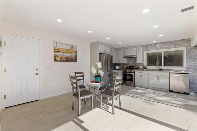 a living room with stainless steel appliances kitchen island granite countertop furniture and a view of kitchen