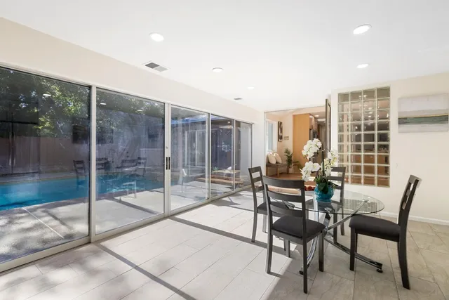 a dining room with furniture and a floor to ceiling window
