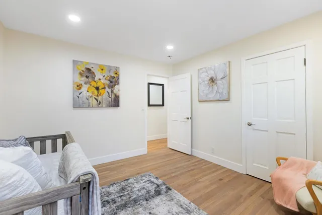 a spacious bedroom with a bed and painting on the wall