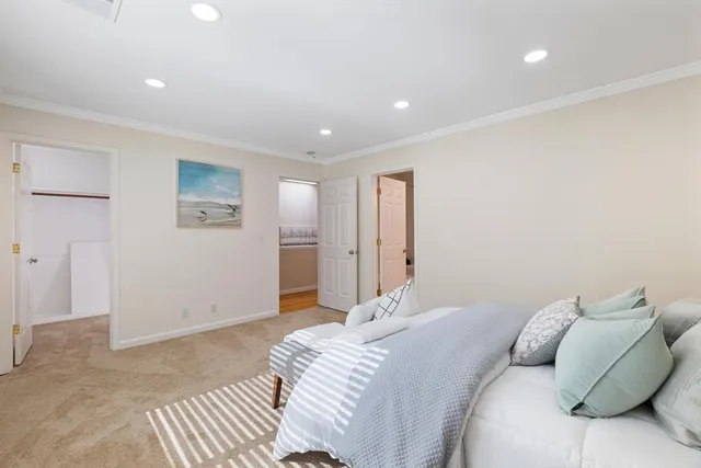 a bedroom with a large bed and a painting on the wall