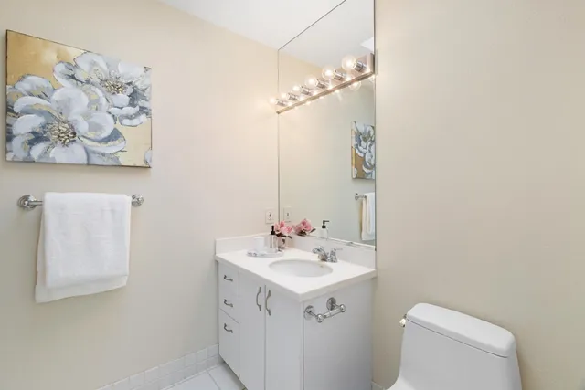 a bathroom with a sink mirror vanity and toilet