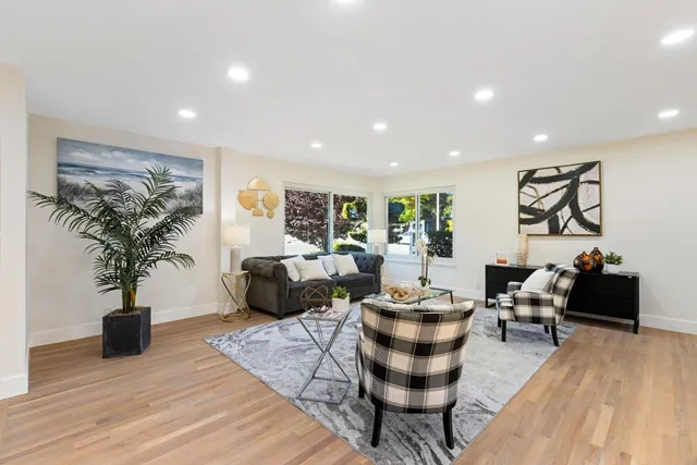 a living room with furniture potted plant and a wooden floor