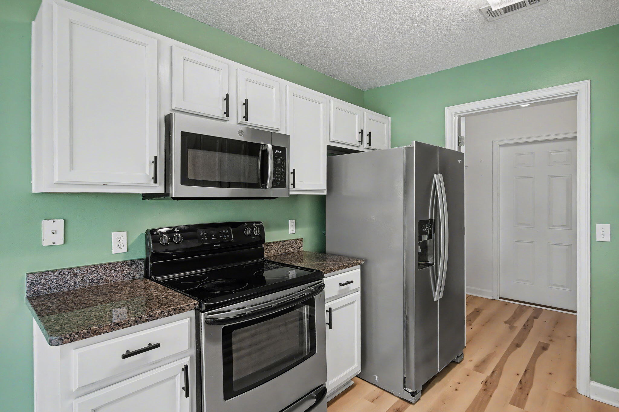 28 3rd Street Shalimar, FL 32579 - Photo 12 of 31 a kitchen with stainless steel appliances granite countertop a stove a refrigerator and a microwave