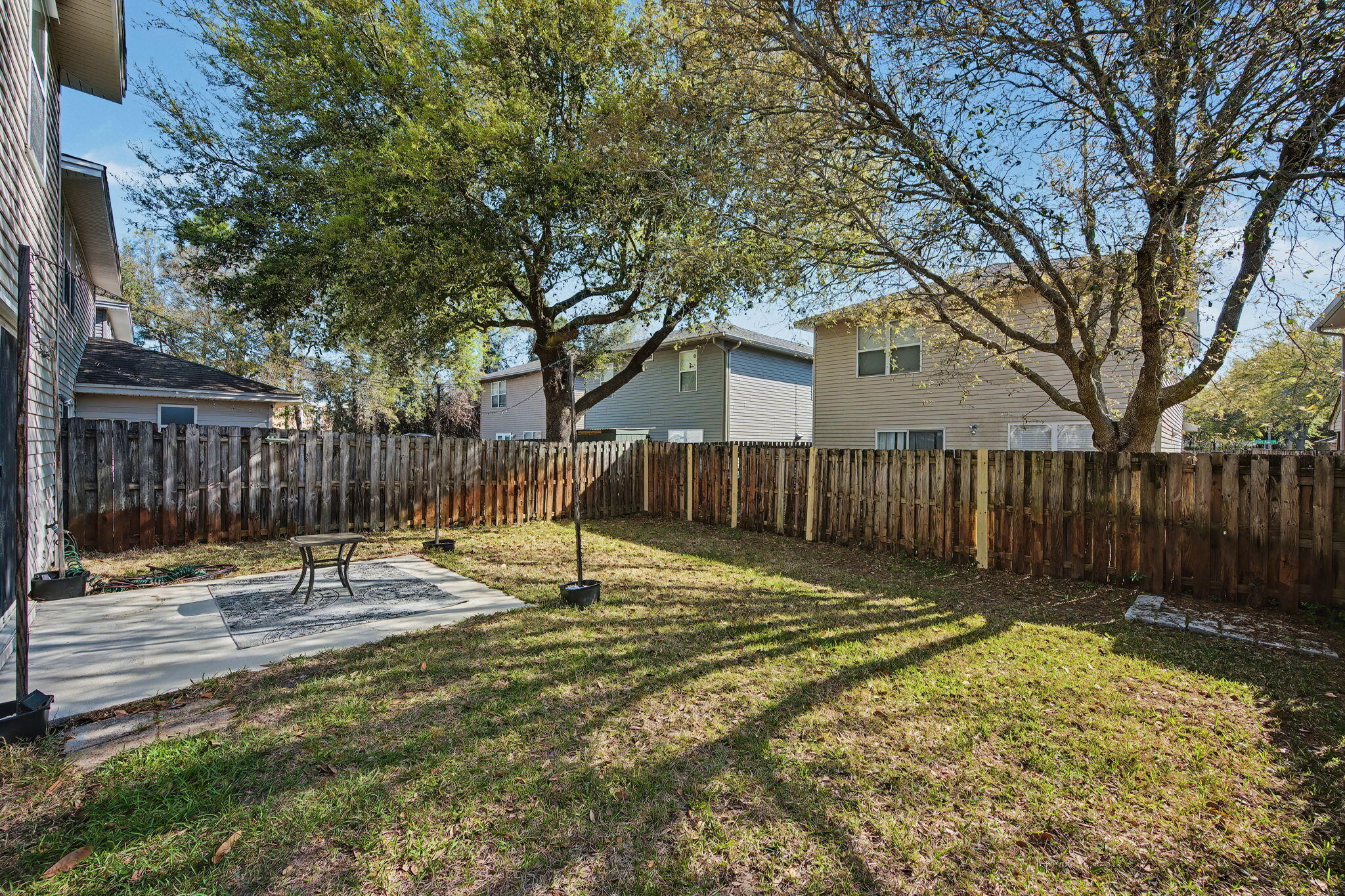 28 3rd Street Shalimar, FL 32579 - Photo 31 of 31 a backyard of house with wooden fence and large trees