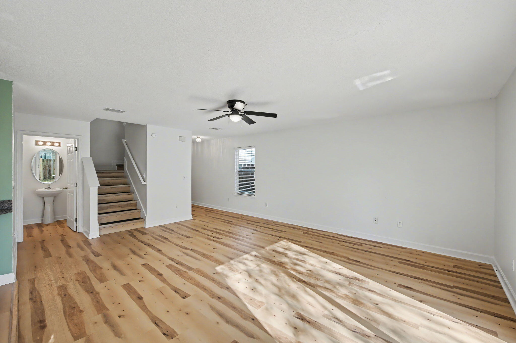 28 3rd Street Shalimar, FL 32579 - Photo 7 of 31 a view of a livingroom with stairs and a ceiling fan