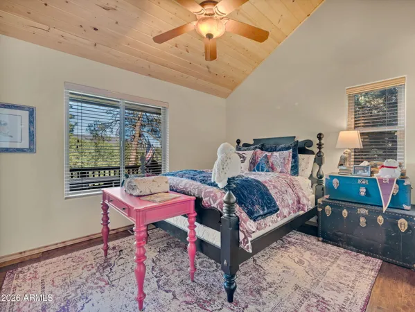 a bedroom with a bed a chandelier and a dresser