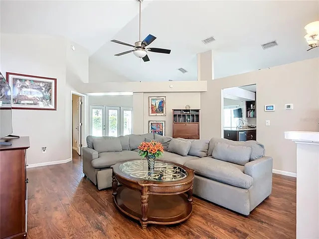 a kitchen with stainless steel appliances granite countertop wooden cabinets a sink a stove a dining table and chairs