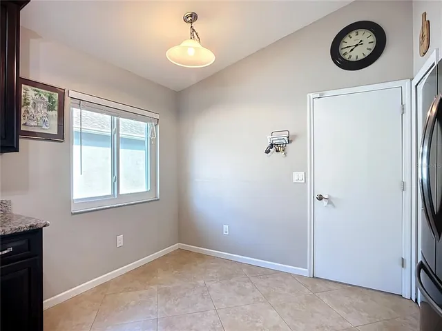 a view of an empty room with wooden floor and windows