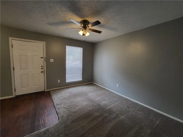 an empty room with closet area and fan