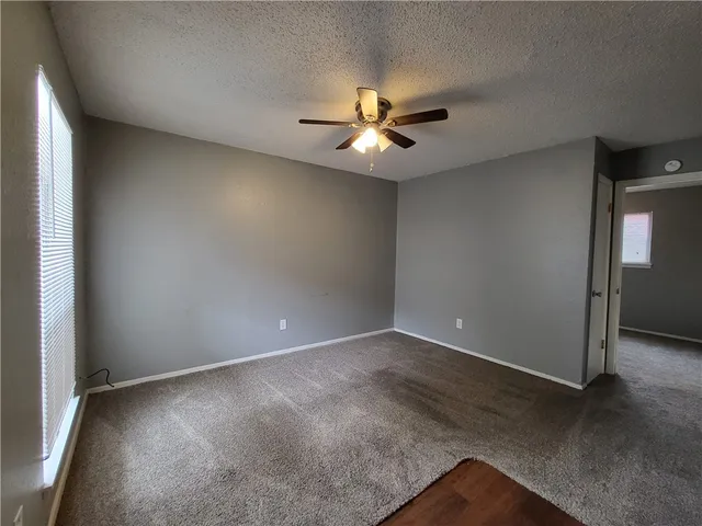an empty room with closet and a chandelier fan