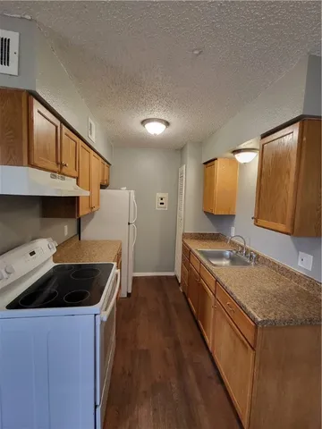 a kitchen with a stove a sink and a refrigerator