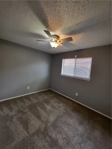 an empty room and a ceiling fan and window