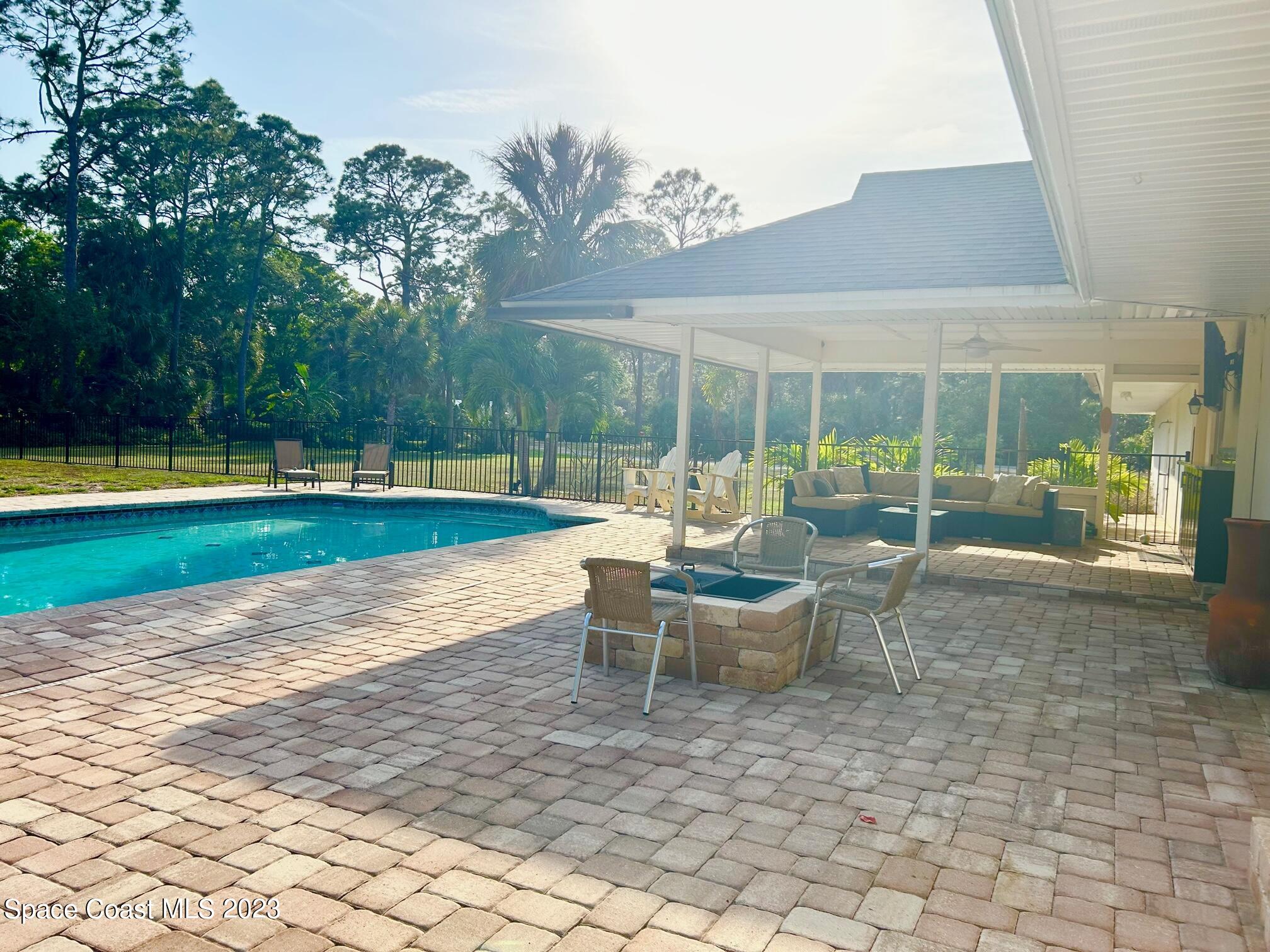 1639 Emmaus Road Northwest Palm Bay, FL 32907 - Photo 19 of 40 a view of a backyard with a patio and fire pit