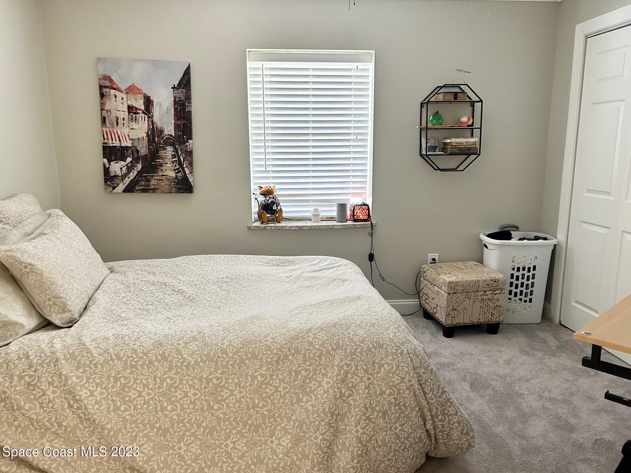 1639 Emmaus Road Northwest Palm Bay, FL 32907 - Photo 25 of 40 a bedroom with a bed and a painting on the wall
