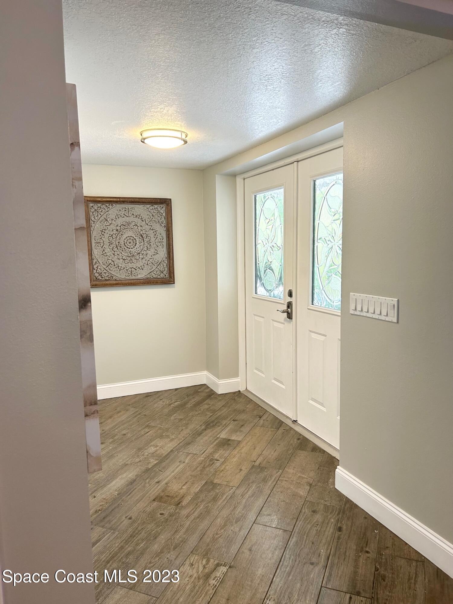 1639 Emmaus Road Northwest Palm Bay, FL 32907 - Photo 3 of 40 an empty room with wooden floor and windows