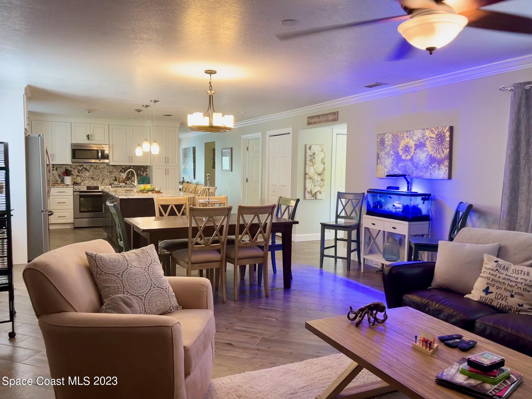 1639 Emmaus Road Northwest Palm Bay, FL 32907 - Photo 5 of 40 a living room with furniture a chandelier and a dining table