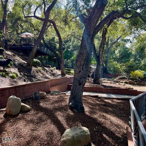 2460 Valley Meadow Drive Oak View, CA 93022 - Photo 41 of 49 a view of a yard with plants and a bench