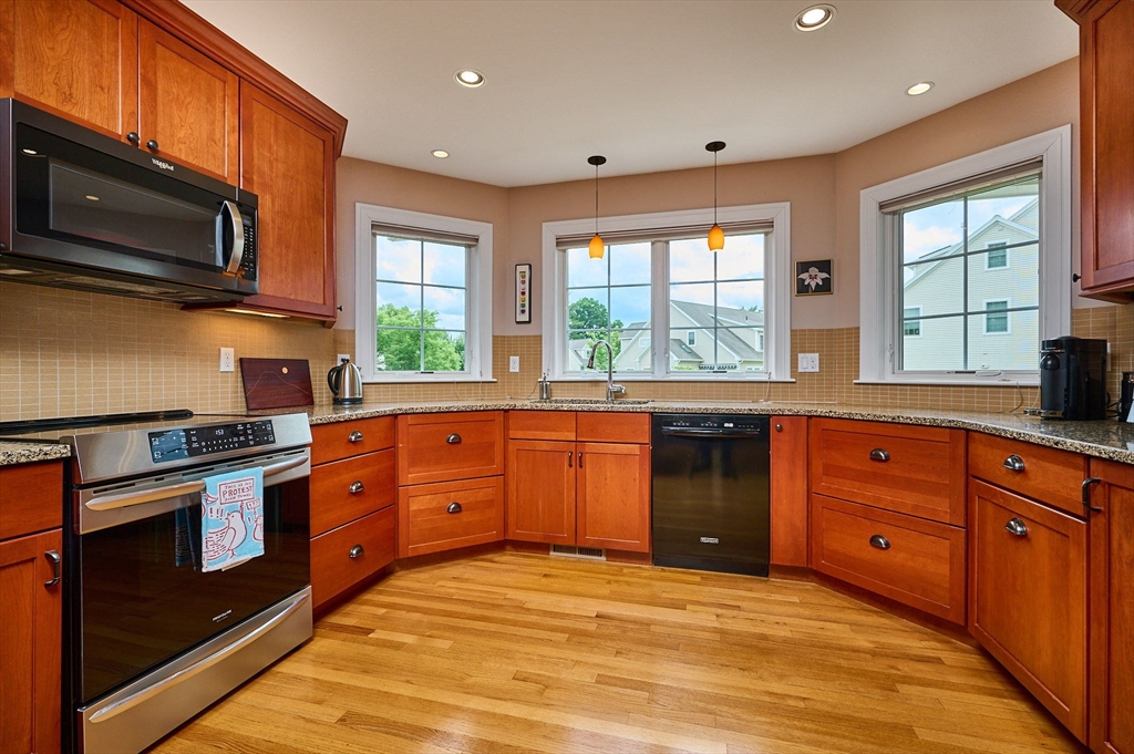 20 Bridge Road, Unit 18 Northampton, MA 01062 - Photo 11 of 42 a large kitchen with stainless steel appliances granite countertop a stove a sink and a microwave