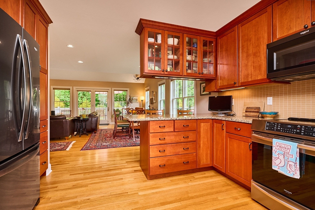 20 Bridge Road, Unit 18 Northampton, MA 01062 - Photo 13 of 42 a kitchen with stainless steel appliances granite countertop a stove top oven a sink dishwasher and cabinets with wooden floor