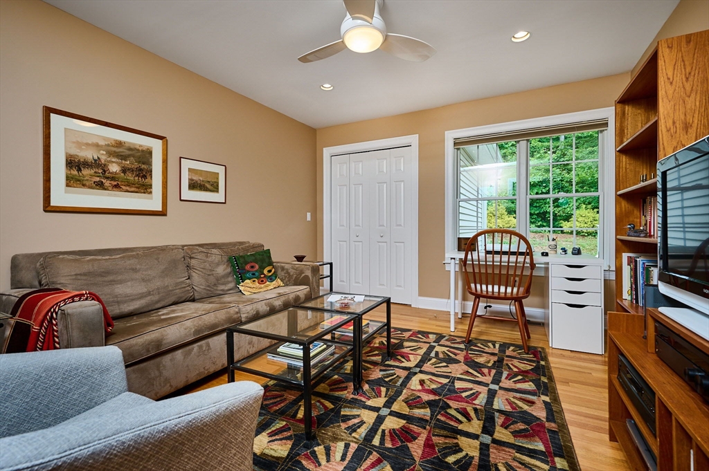 20 Bridge Road, Unit 18 Northampton, MA 01062 - Photo 18 of 42 a living room with furniture a flat screen tv and a floor to ceiling window