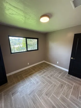 an empty room with wooden floor and window
