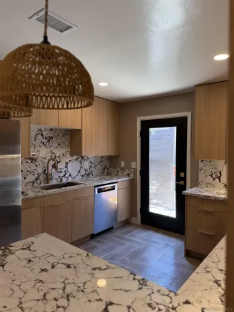 a kitchen with stainless steel appliances granite countertop a stove a sink and a refrigerator