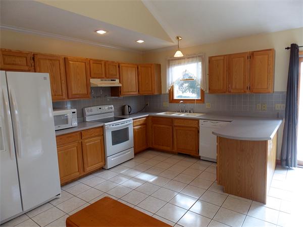 22 Dunbar Street Springfield, MA 01118 - Photo 5 of 21 a kitchen with a sink a refrigerator and cabinets