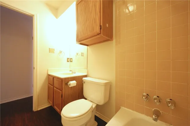 a bathroom with a toilet a sink and mirror