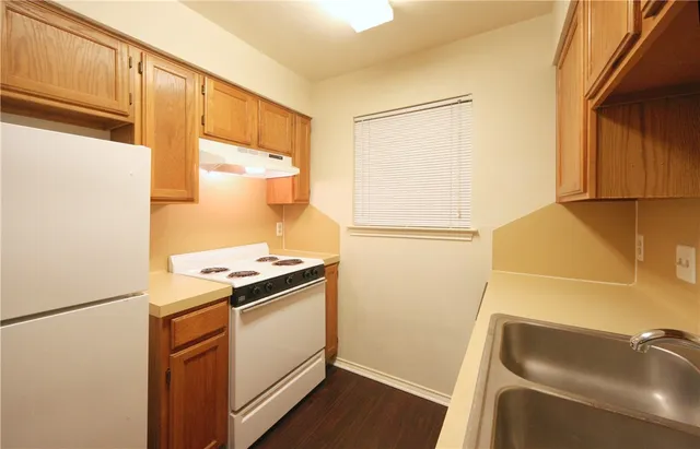 a kitchen with a refrigerator sink stove and cabinets