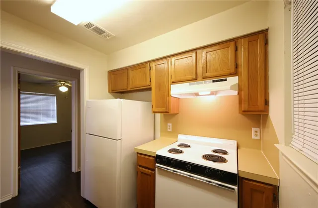 a kitchen with a refrigerator and a stove