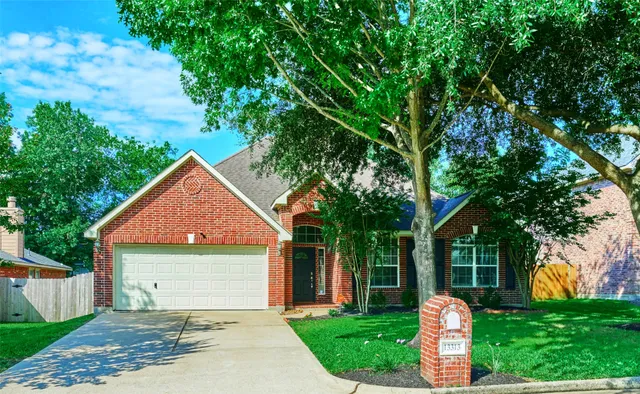 a front view of a house with a yard and tree s