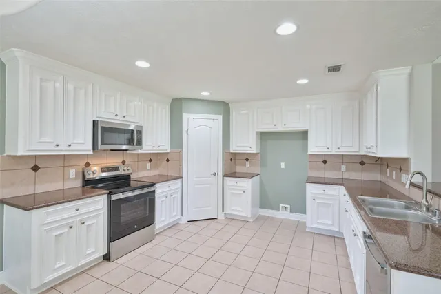 a kitchen with a sink a stove and cabinets