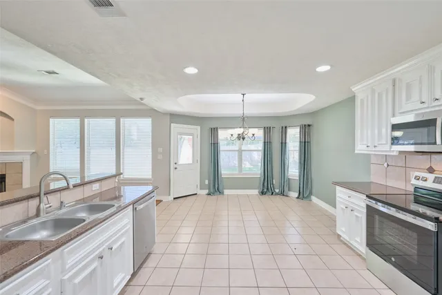 a kitchen with white cabinets sink and stainless steel appliances