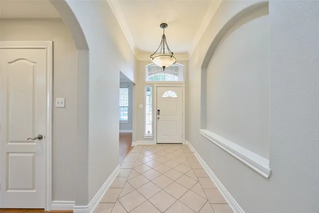 a view of a hallway with a chandelier and entryway