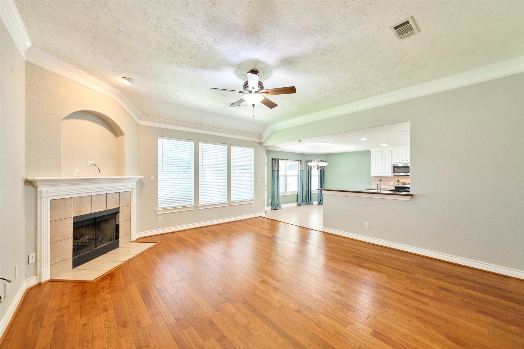 13313 Enchanted Way Montgomery, TX 77356 - Photo 4 of 36 a view of an empty room with chandelier fan and wooden floor